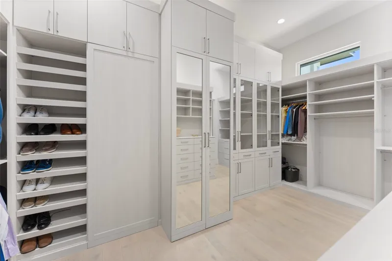 Closet planejado com sapateira, armários espelhados e portas de vidro
